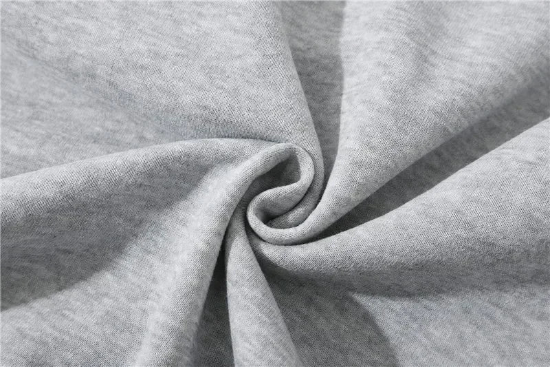 Close-up of gray fabric, soft texture, twisted in a spiral, highlighting folds and shadows.